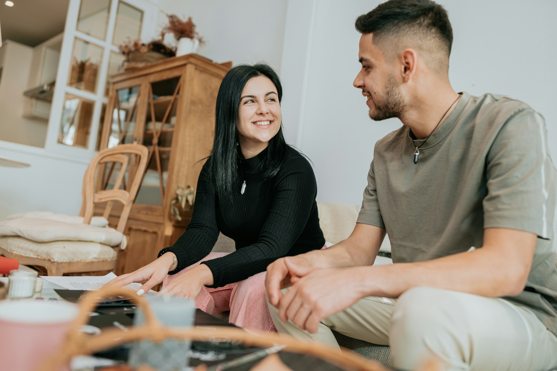 A couple smiling at each other while sitting together at home