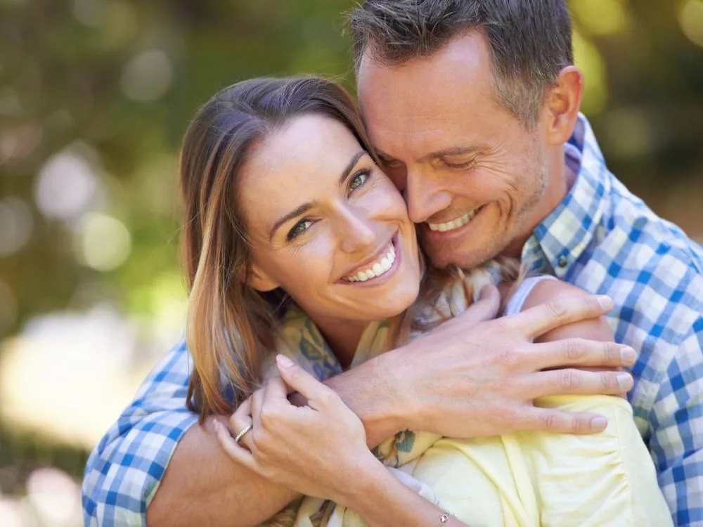 A smiling couple embracing outdoors