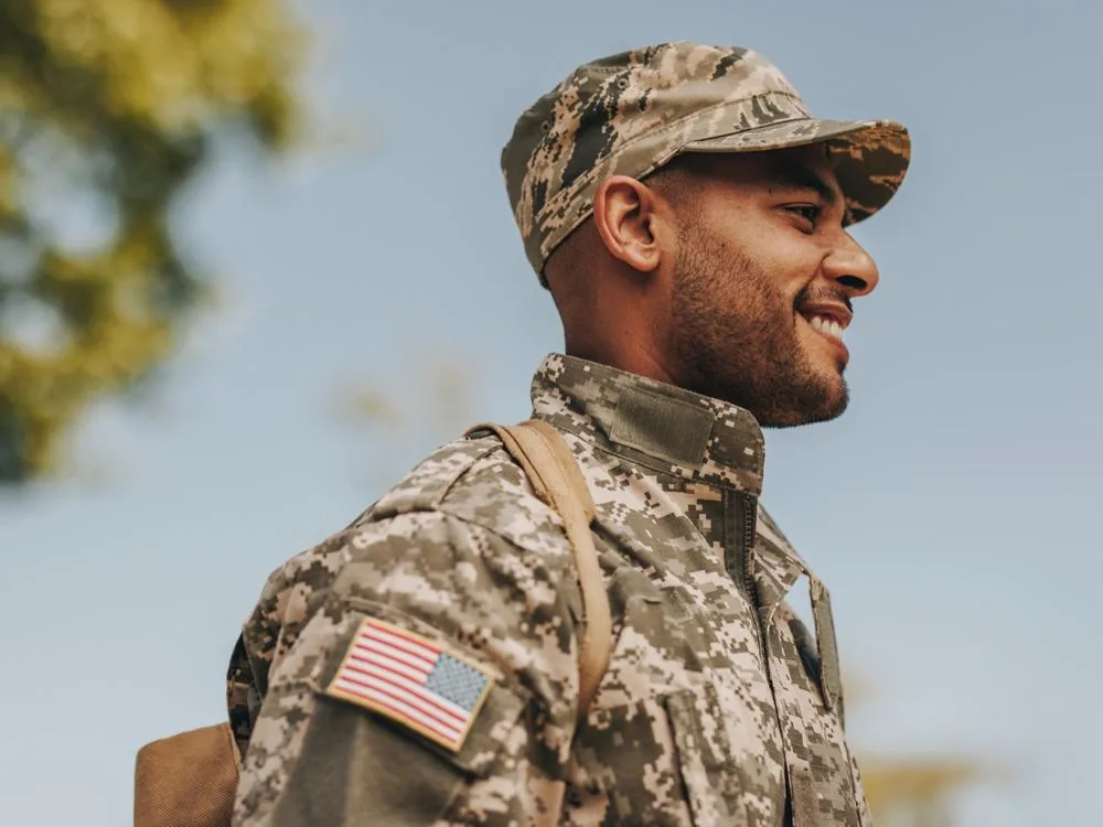 A smiling service member in uniform outdoors
