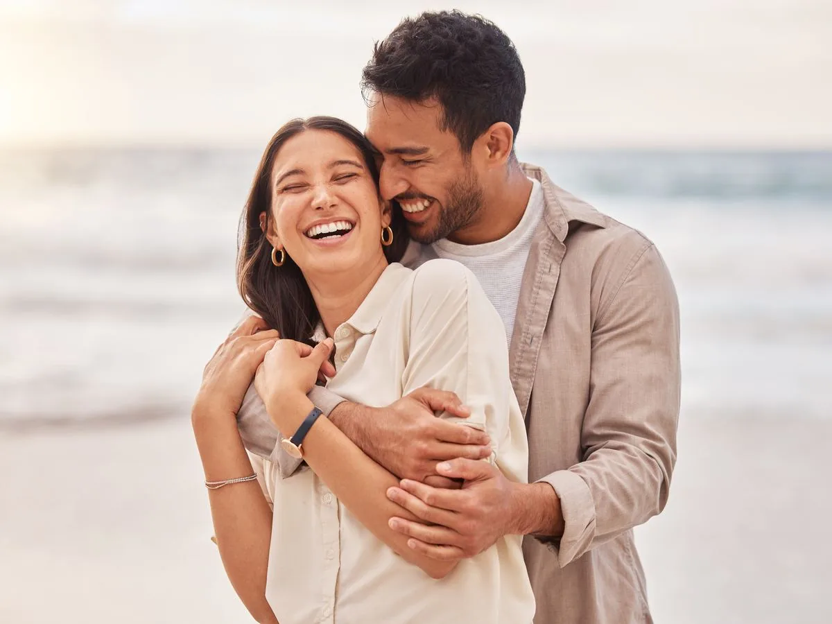 A joyful couple embracing near the beach